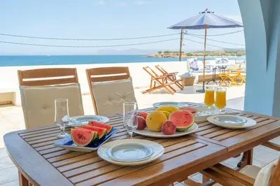 a wooden table with a plate of fruit on it at Beach House Kalamaki steps away from the beach in Galatás
