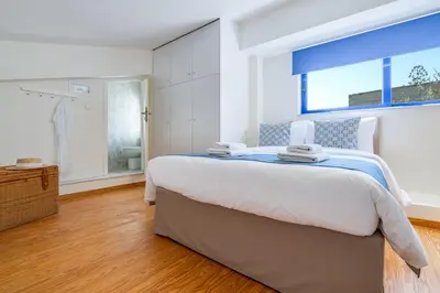 a bedroom with a large bed and a window at Beach House Kalamaki steps away from the beach in Galatás
