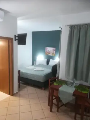 a bedroom with a bed and a couch and a table at Mari Helen in Kamisianá