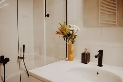a bathroom sink with a vase of flowers on it at Kale Kapi City Living in Chania Town