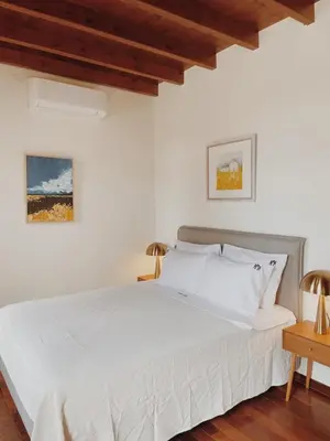 a white bedroom with a white bed and two lamps at Kale Kapi City Living in Chania Town