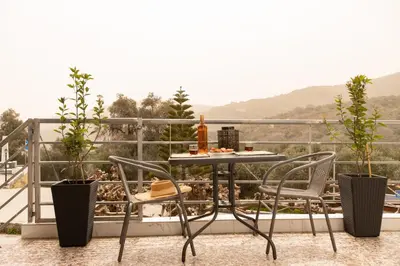 a table and chairs on a balcony with plants at Square Apartment in Kambanós