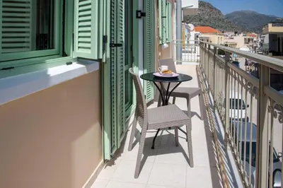 a balcony with a table and chairs on it at Erontas Apartment in Palaiochóra