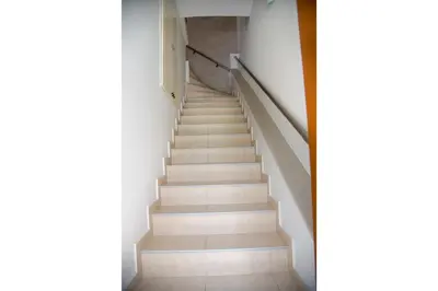 a staircase in a building with white floors at Erontas Apartment in Palaiochóra