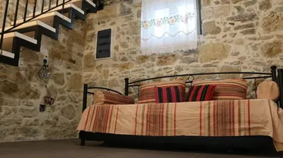 a bedroom with a bed in a stone wall at Mouri Village in Aïkiryiánnis