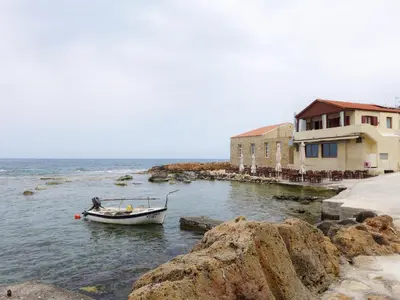 a small boat in the water next to a building at FOS - casa casa group in Chania Town