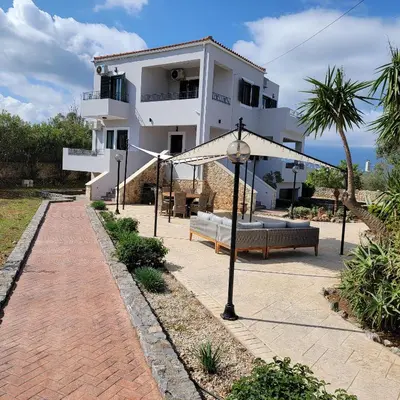 a white house with a brick walkway in front of it at Paradisos Villa - Chania, Crete in Litsárdha