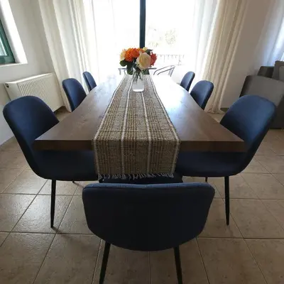 a wooden table with blue chairs and a vase of flowers at Paradisos Villa - Chania, Crete in Litsárdha