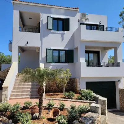 a white house with some trees in front of it at Paradisos Villa - Chania, Crete in Litsárdha