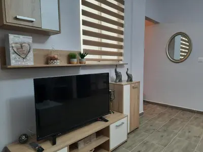 a flat screen tv sitting on top of a wooden entertainment center at SummerSense Apartment in Chania Town