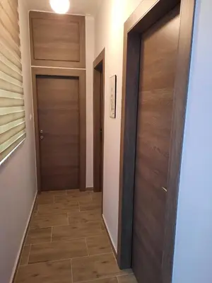 a hallway with two wooden doors and a tile floor at SummerSense Apartment in Chania Town