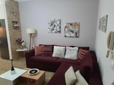 a living room with a brown couch and some paintings at SummerSense Apartment in Chania Town