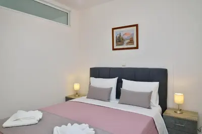 a bedroom with a large bed with two lamps at Gavalas Urban Home in Chania Town