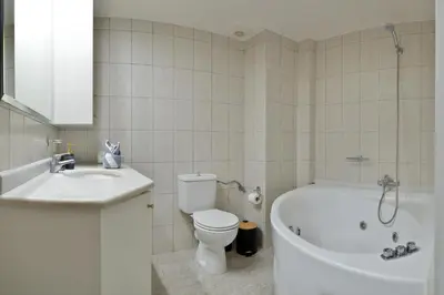 a bathroom with a tub and a toilet and a sink at Gavalas Urban Home in Chania Town