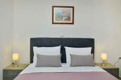 a bed with a black headboard and two lamps at Gavalas Urban Home in Chania Town