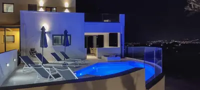 a house with a swimming pool and chairs at Casa Galatas in Galatás