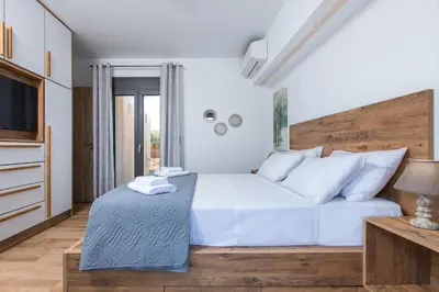 a bedroom with a white bed and a television at Casa Galatas in Galatás