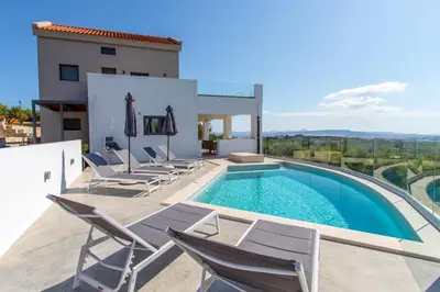 a villa with a swimming pool and chairs at Casa Galatas in Galatás