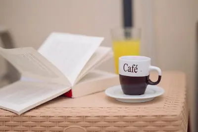 a cup of coffee sitting on a table with books at The Morus House with Private pool in Melidhónion