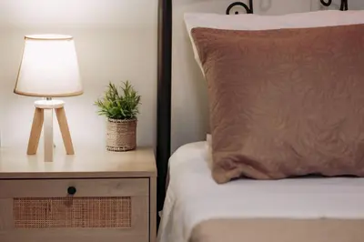 a bed with a pillow and a lamp on a night stand at The Morus House with Private pool in Melidhónion