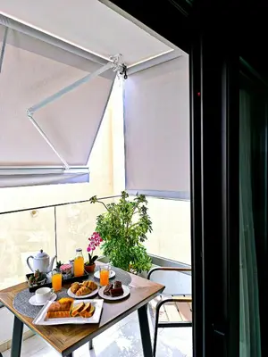 a table with food and orange juice on it at Avanti Chania Luxury Apartment in Chania Town