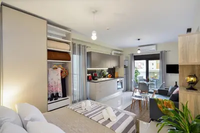 a kitchen and living room with a couch and a table at Avanti Chania Luxury Apartment in Chania Town