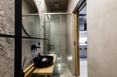 a bathroom with a black bowl sink and a glass shower at Omma Villas in Chania Town