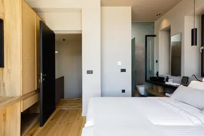 a bedroom with a white bed and a bathroom at Omma Villas in Chania Town