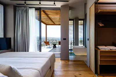a bedroom with a large bed and a balcony at Omma Villas in Chania Town