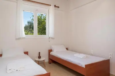 two beds in a room with a window at Villa Cleronomia, private pool, seaview, in Kaloudhianá