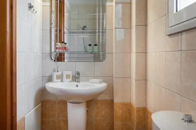a bathroom with a sink and a mirror at Villa Cleronomia, private pool, seaview, in Kaloudhianá