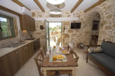 a kitchen and dining room with a table with food on it at Pamelas House with Jacuzzi in Kissamos