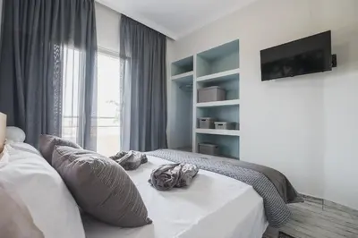 a bedroom with a bed with pillows and a television at D&G Lux Flat City View next to Old Town & Market in Chania Town