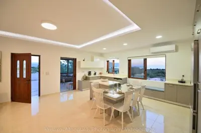 a kitchen and dining room with a table and chairs at Ianthe Apartment in Kissamos