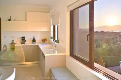 a kitchen with a large window and a sink at Ianthe Apartment in Kissamos