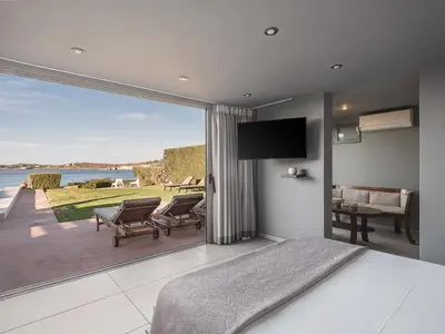 a bedroom with a large window with a view of the water at VILLA NIBA in Kalathas