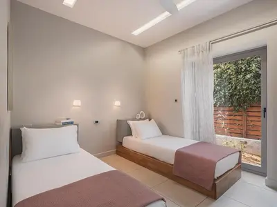 two beds in a room with a window at VILLA NIBA in Kalathas