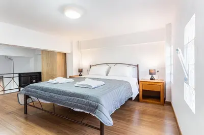 a bedroom with a large bed and a wooden floor at Neva's Apartment's in Center Chania 1 2 in Chania Town