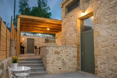 a stone house with a green door and a patio at Casa Piedra in Nohia