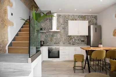 a kitchen with a dining table and a staircase at Casa Piedra in Nohia