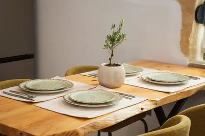 a wooden table with plates and a vase on it at Casa Piedra in Nohia