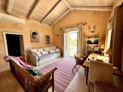 a living room with a couch and a table at Maison Théia, entre mer et montagne Samonas in Samonás