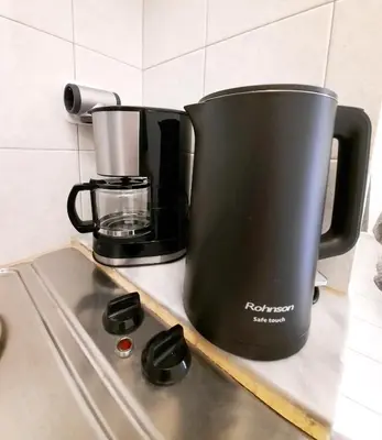a black coffee pot sitting on top of a stove at Stelios Studios Sougia in Sougia