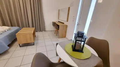 a room with a table and chairs and a bed at Stelios Studios Sougia in Sougia