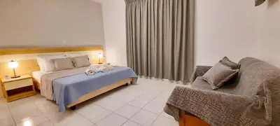 a hotel room with a bed and a couch at Stelios Studios Sougia in Sougia