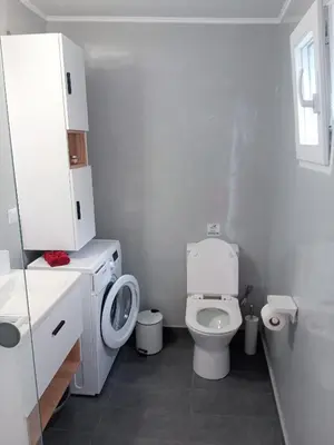 a white bathroom with a toilet and a sink at Sea U in Chania Town