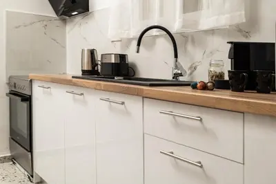 a kitchen with white cabinets and a sink at Michalis NCHouse 33 in Chania Town