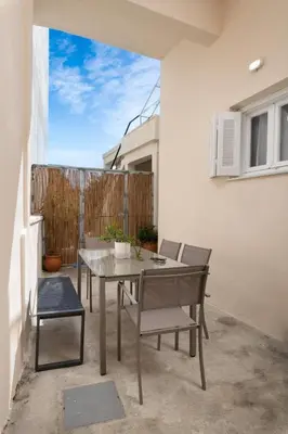 a patio with a table and chairs and a fence at Michalis NCHouse 33 in Chania Town
