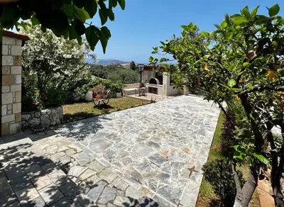 a stone walkway in a yard with a tree at Anestis Ioanna Villa in Daratso