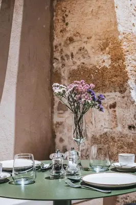 a table with a vase of flowers on it at AZADE Chania in Chania Town